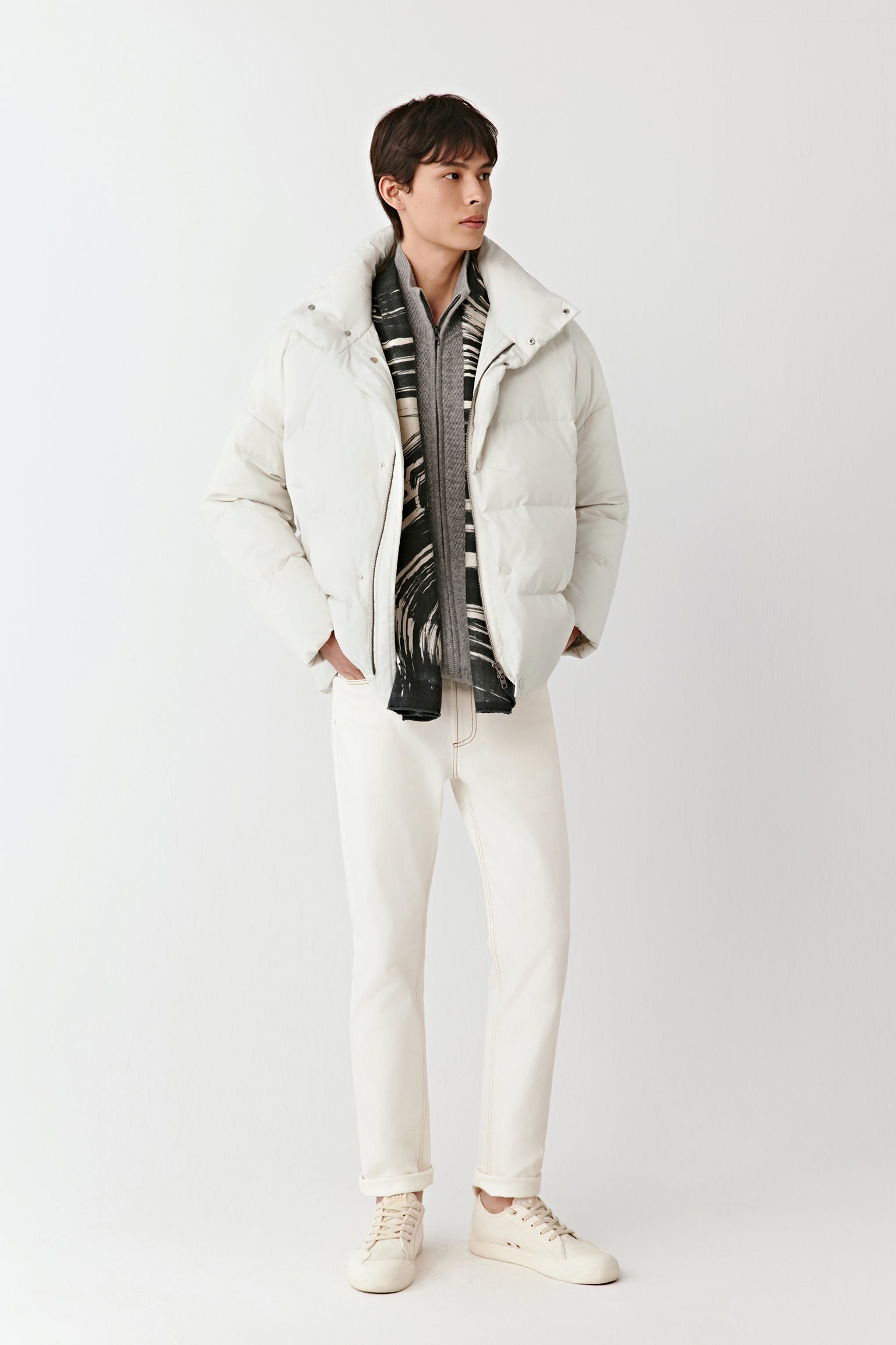 Three-quarter view of the cream puffer coat, showing the zip fastening concealed by a press-stud placket.