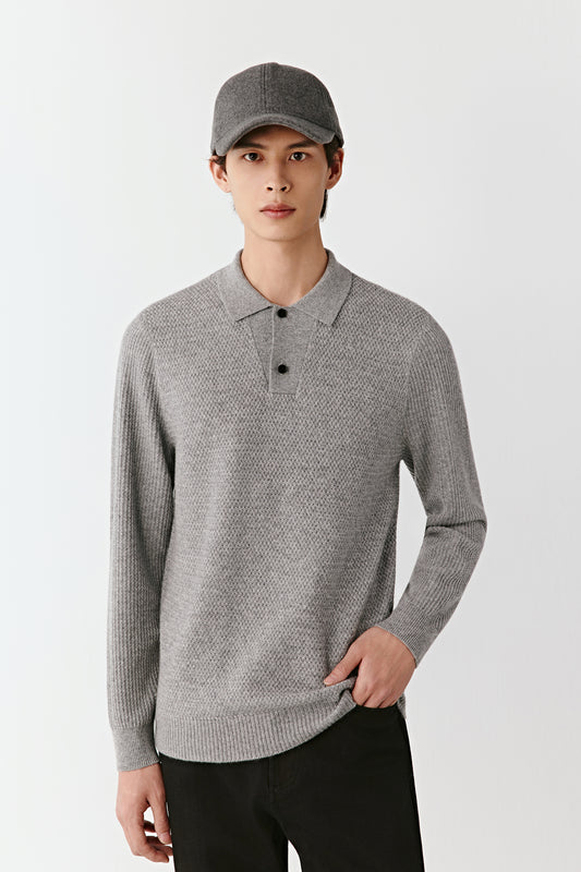 Man wearing a gray patterned sweater and cap on a white background