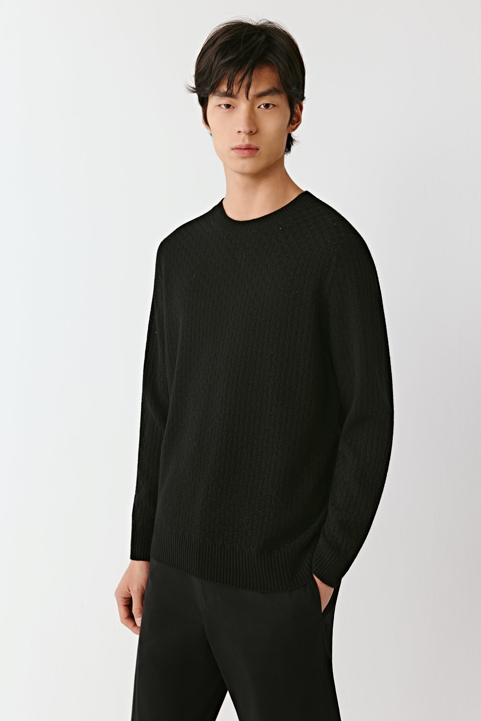 Side view of the black wool pullover, highlighting the fluid silhouette and lightweight knit.