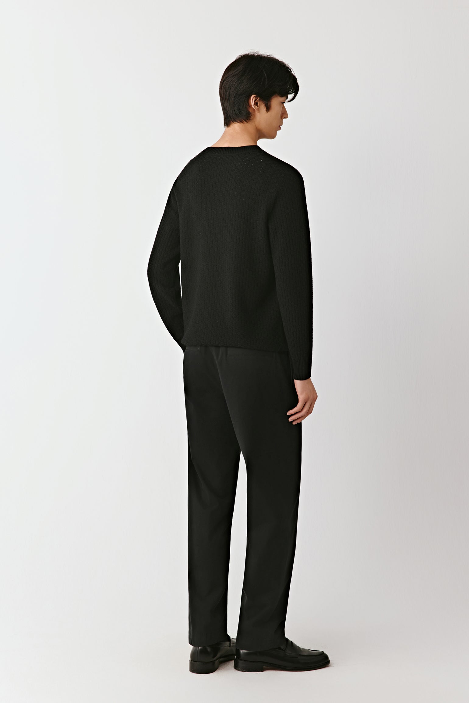 Back view of the black wool pullover, showing its straight fit and smooth knit texture.