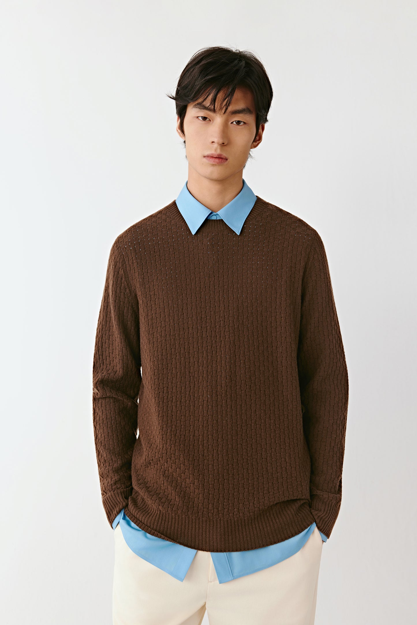 Three-quarter view of the brown wool pullover, showing ribbed trims and a relaxed, comfortable fit.