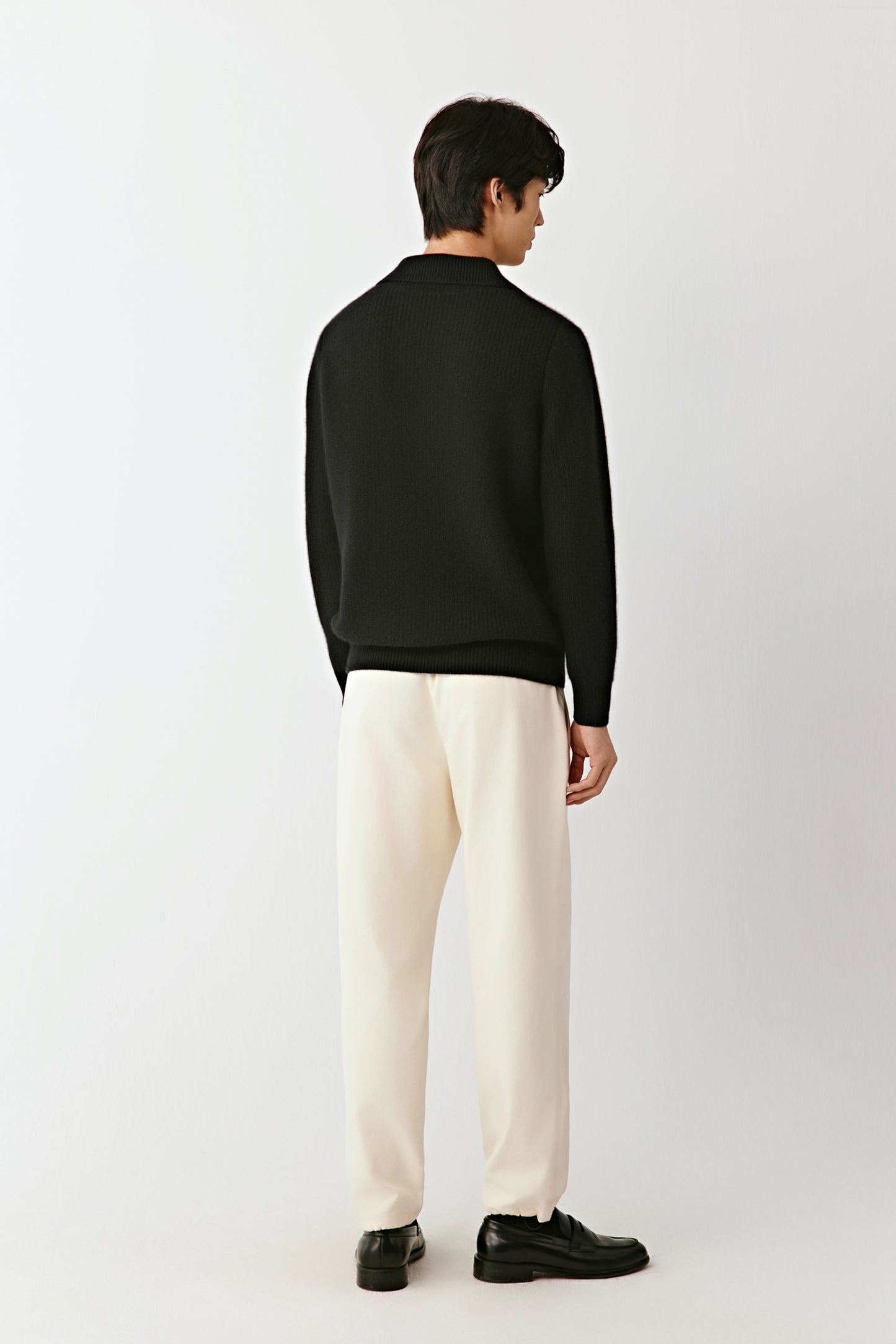 Back view of the black cashmere polo sweater, showing the smooth knit and straight fit.