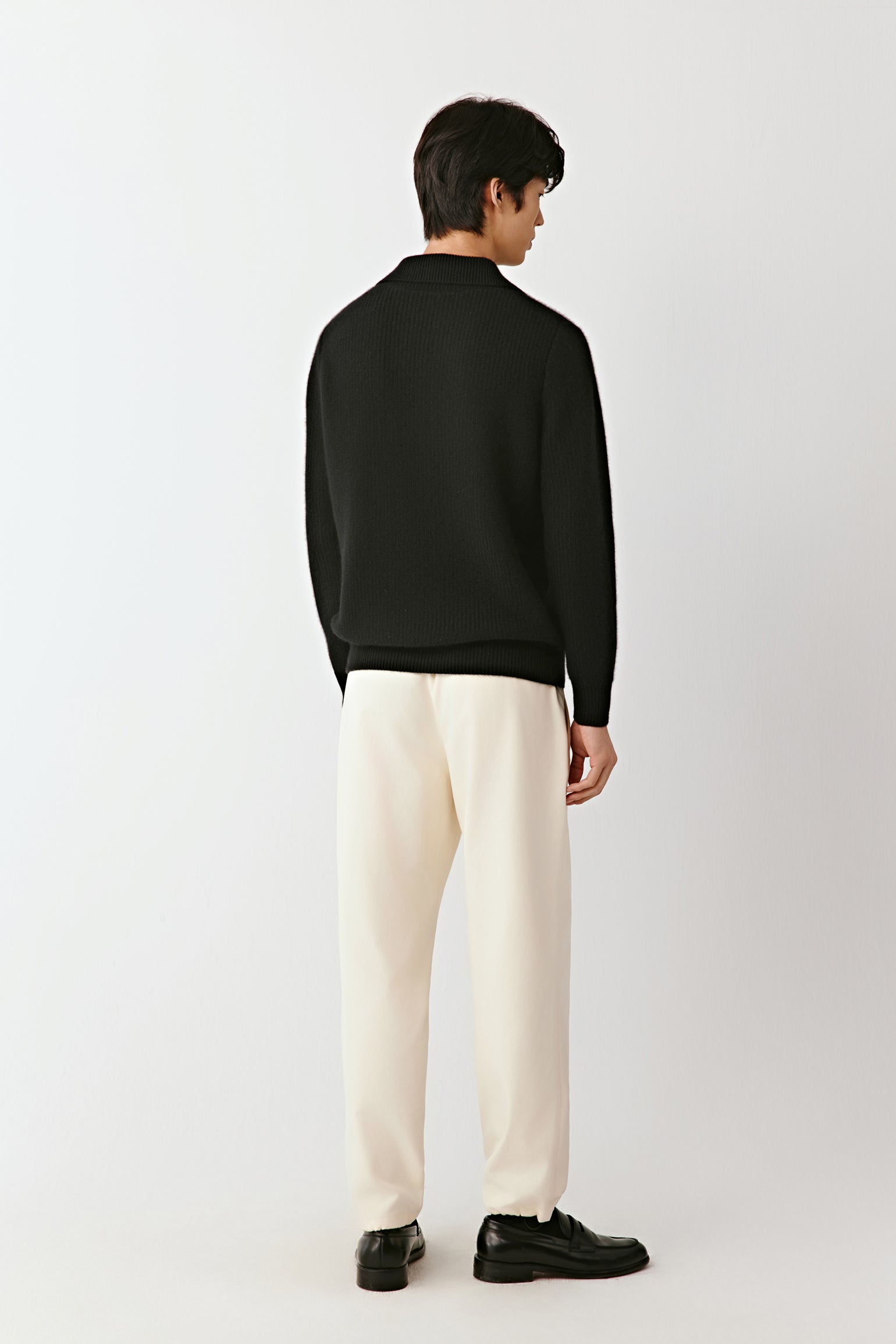 Back view of the black cashmere polo sweater, showing the smooth knit and straight fit.