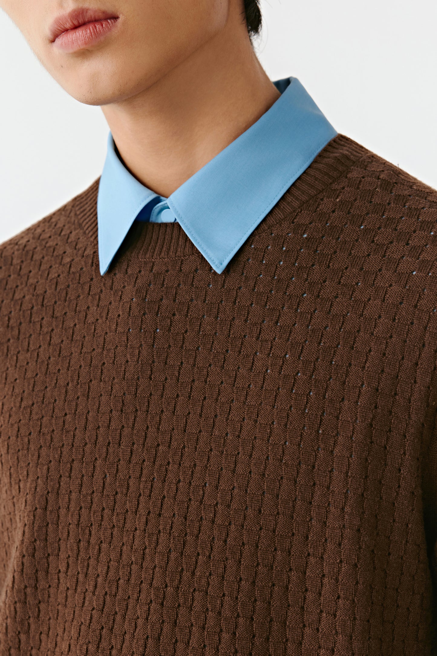 Close-up of the brown wool pullover’s crew neckline and ribbed trim.