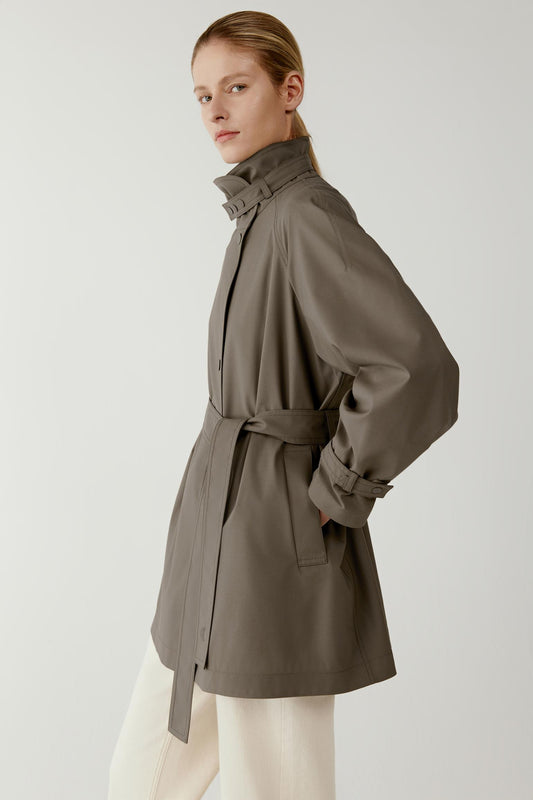 Side view showing the clean lines of the coat, high collar and relaxed sleeve shape.