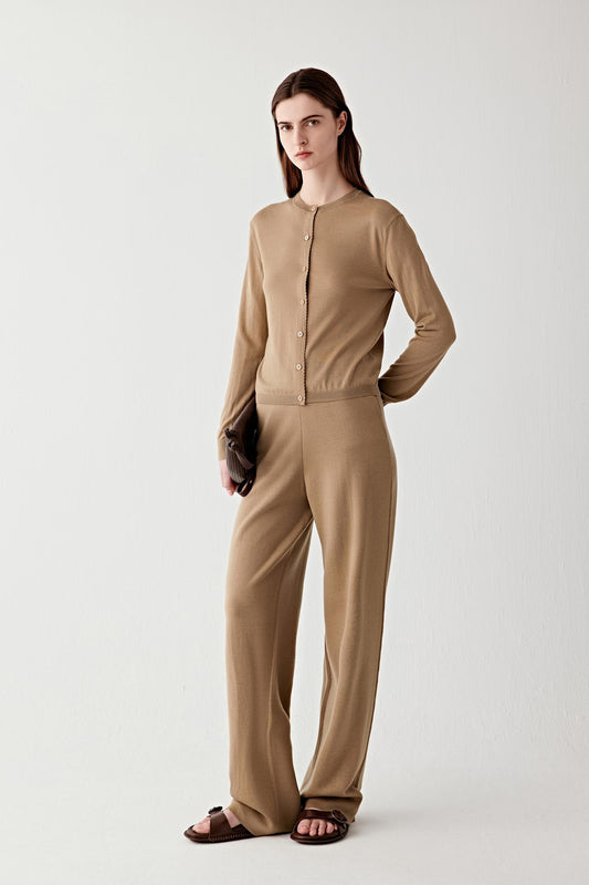 Full-length front view of wide-leg wool trousers in a camel shade, showing the elongated silhouette and fluid drape.