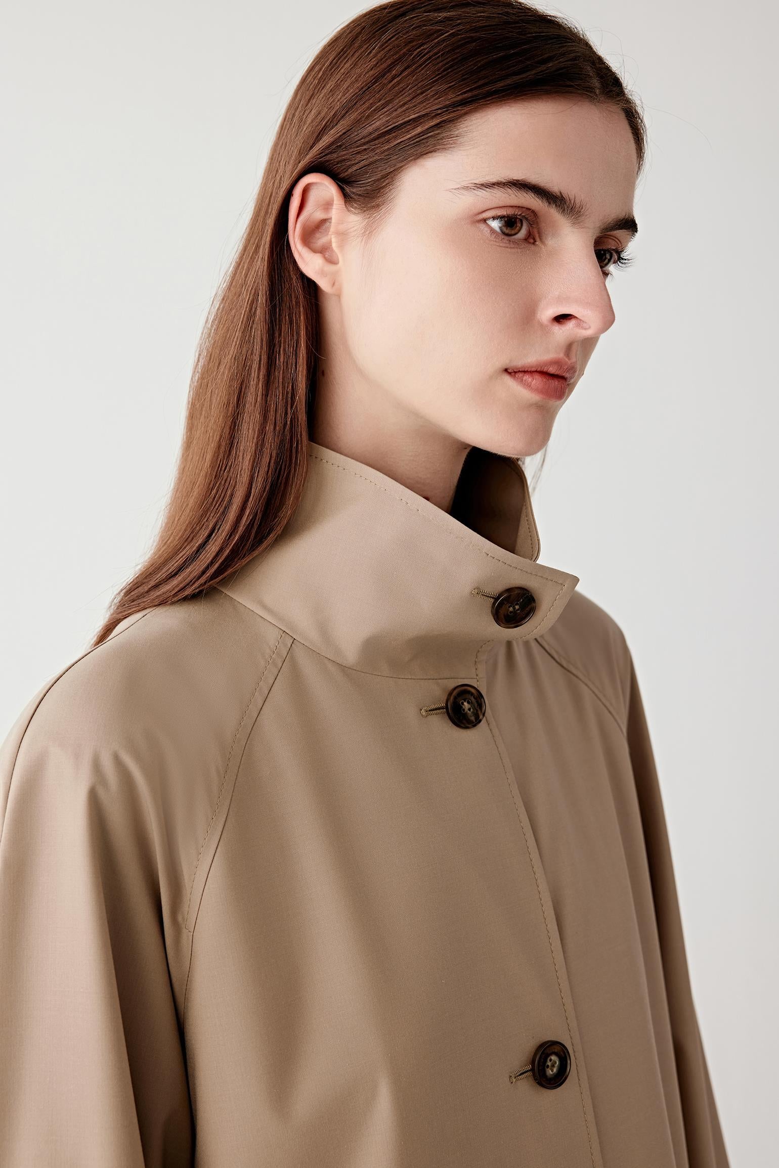 Close-up detail of the button fastening and fabric surface, showing refined finishing and tonal stitching.