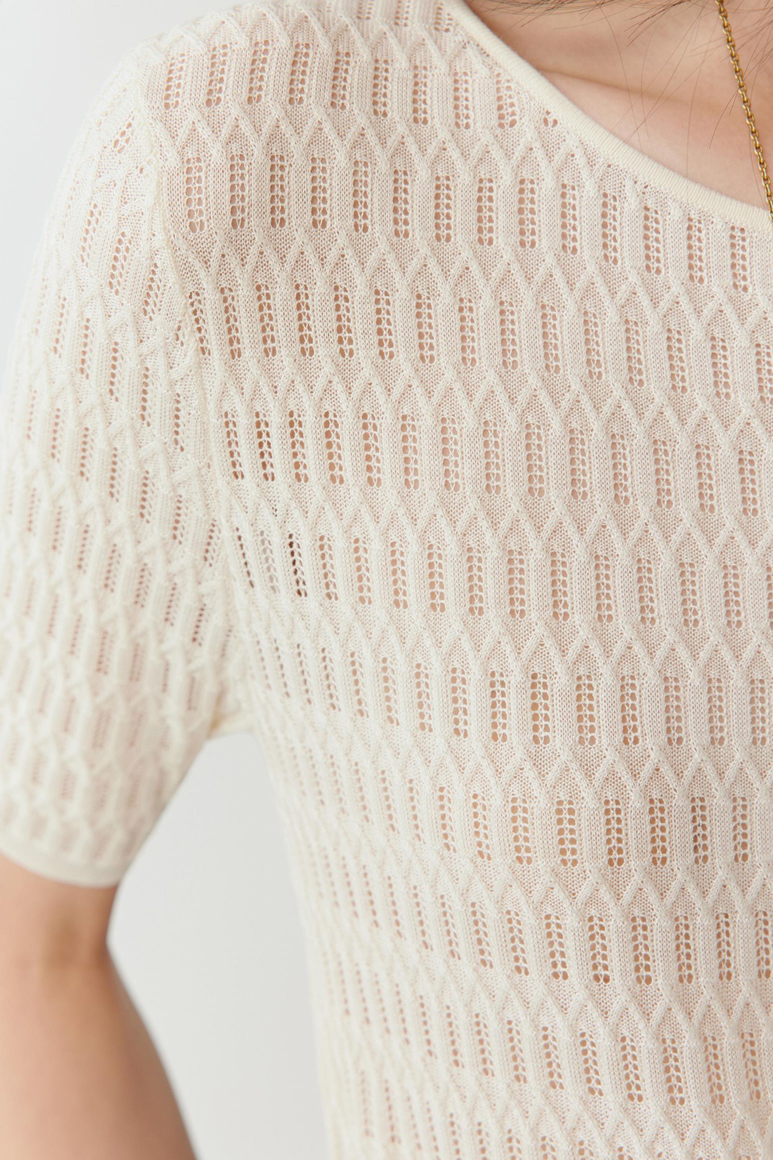 Close-up of the knit texture, showing the openwork pattern, irregular grid structure and natural fibre finish.