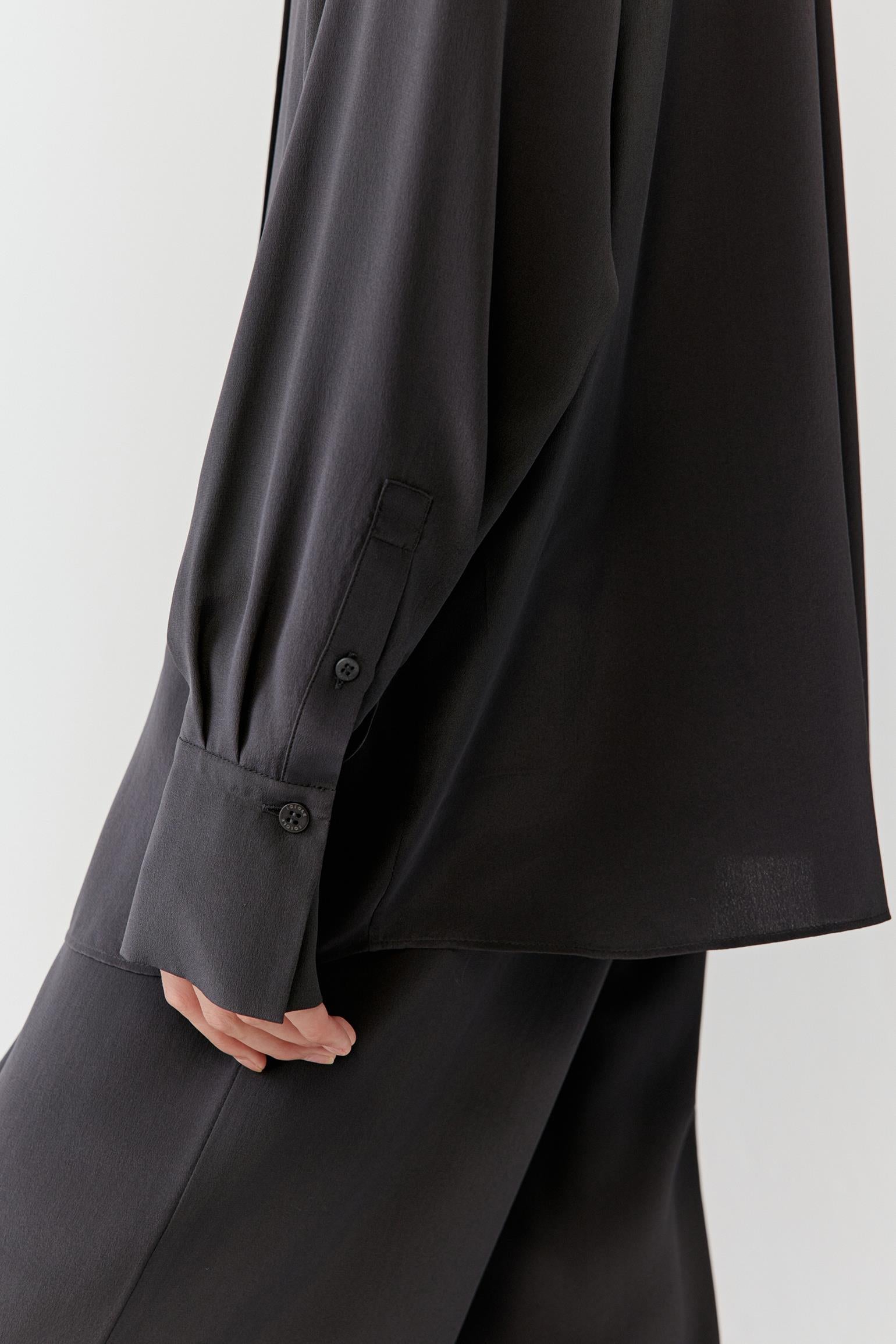 Detail of the cuff and sleeve, highlighting the soft movement of the fabric and buttoned cuff construction.
