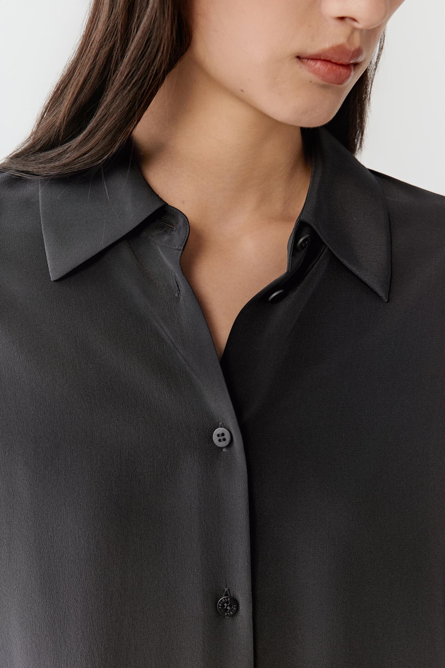 Close-up of the collar and button placket, showing the smooth crepe de chine texture and refined finishing.