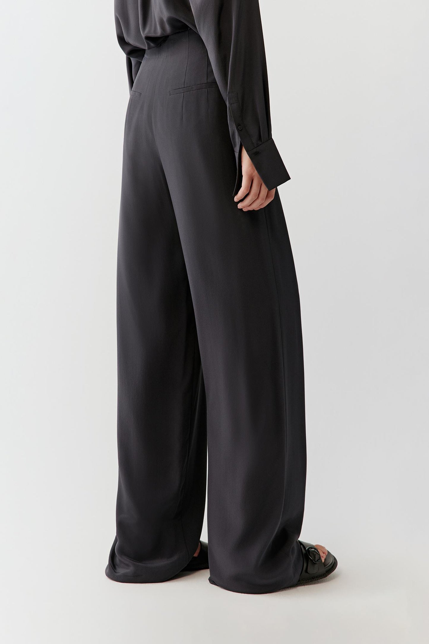 Side view emphasizing the fluid fall of the silk along the leg and the relaxed, straight cut.