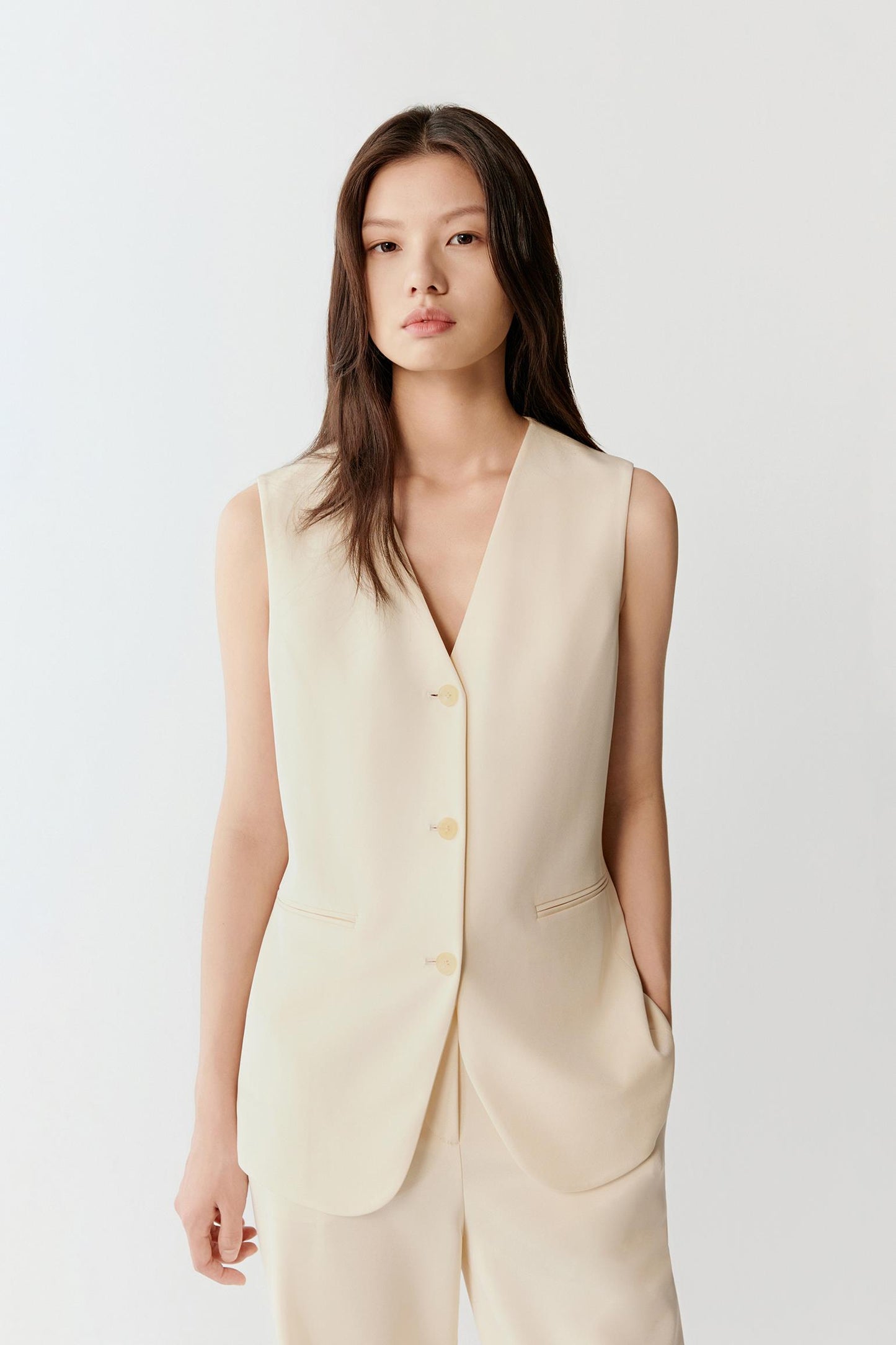 Front three-quarter view emphasizing the tailored silhouette, fitted through the chest with a gentle ease at the waist, and the vertical line created by the button placket.