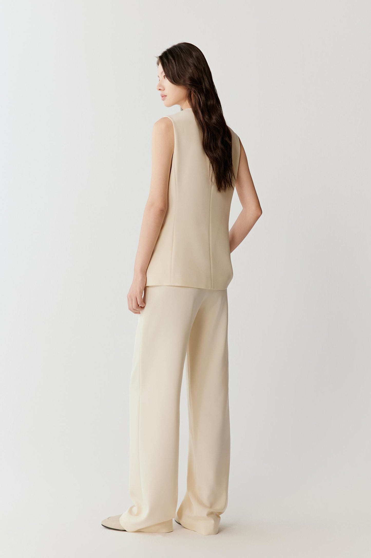 Back view highlighting the clean, straight cut through the body, slightly structured shoulder line and smooth fall of the fabric along the torso and hips.