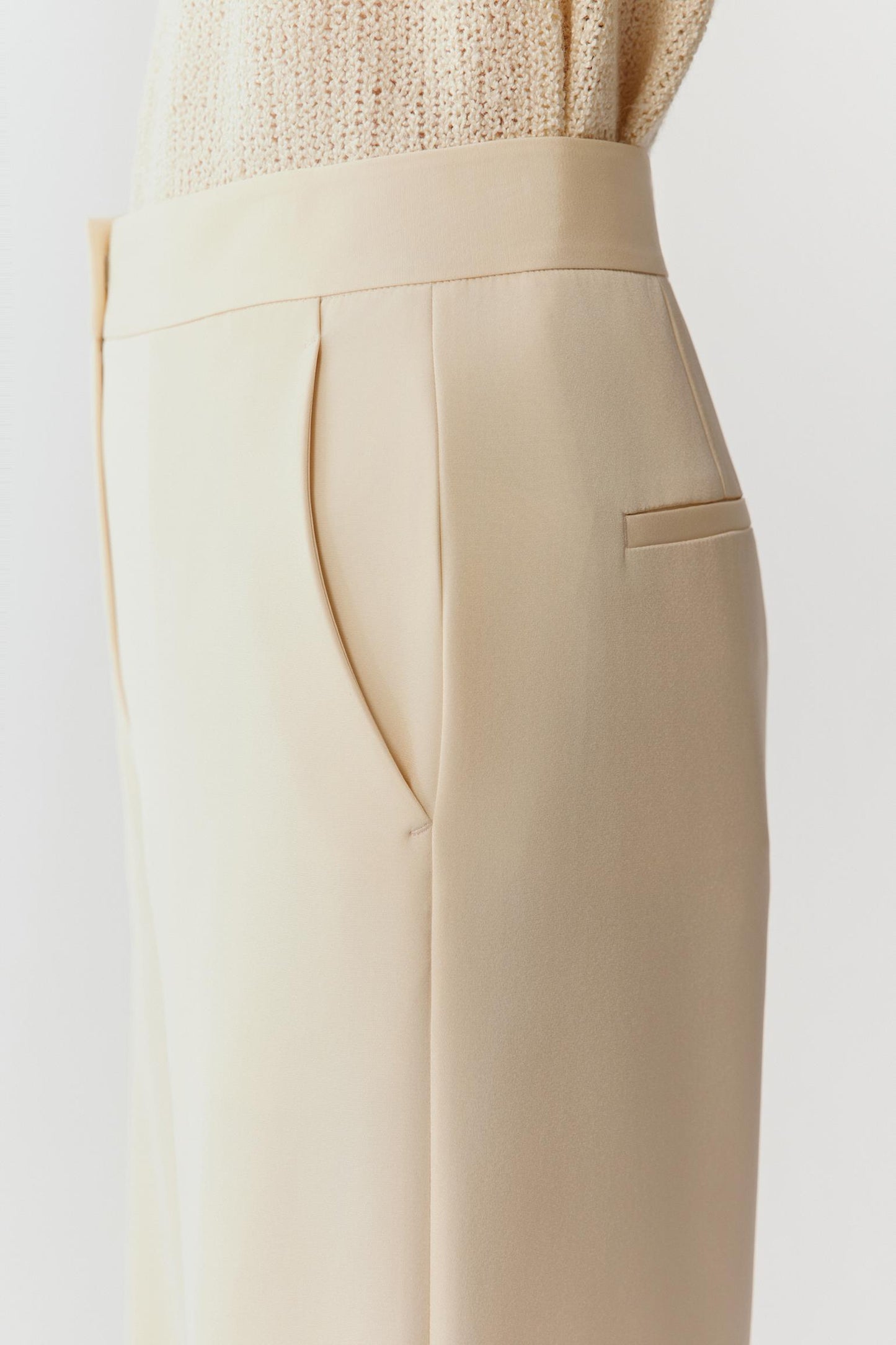 Close-up of the upper hip and waistband, highlighting the fine crepe surface, matte finish and precise seam construction with minimal detailing.