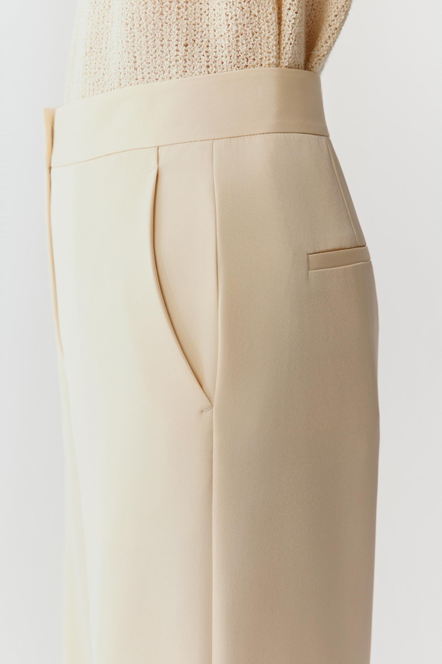 Close-up of the upper hip and waistband, highlighting the fine crepe surface, matte finish and precise seam construction with minimal detailing.