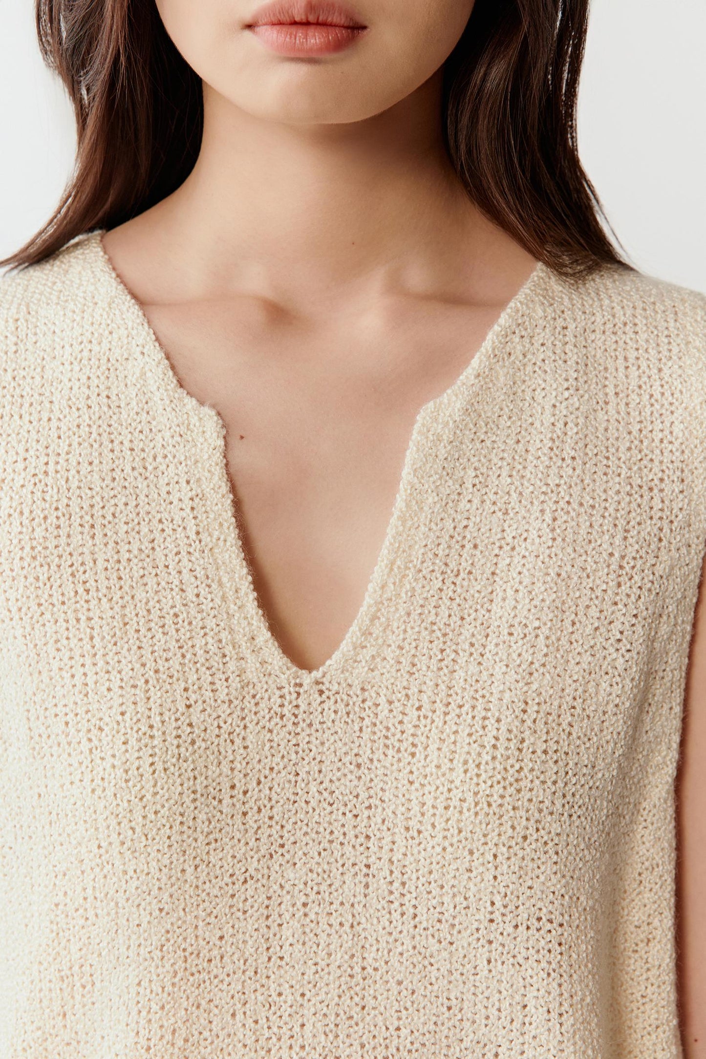 Close-up of the V-neckline and knit texture, highlighting the slightly irregular surface and soft finish of the silk yarn.