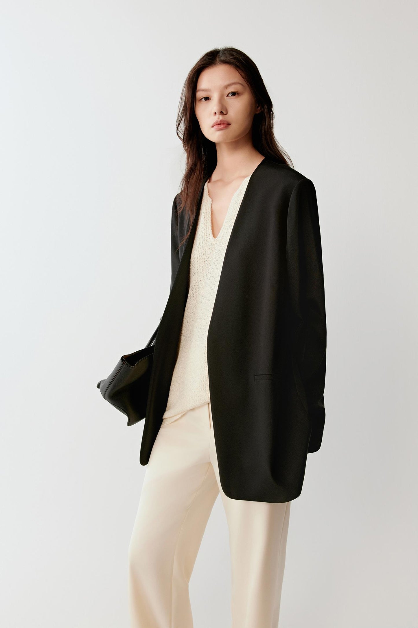 Three-quarter view highlighting the structured yet fluid fall of the blazer and its length along the body.