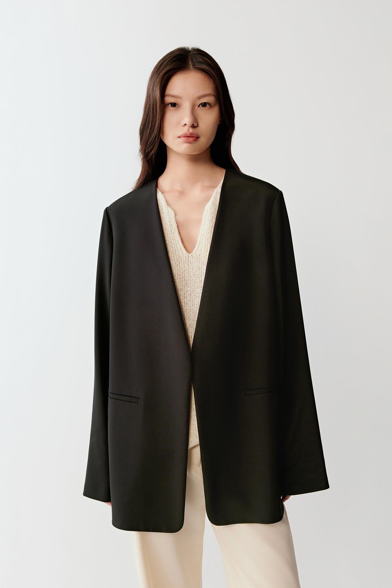 Front view with arms slightly in motion, emphasizing the lightweight fabric and natural movement of the blazer.
