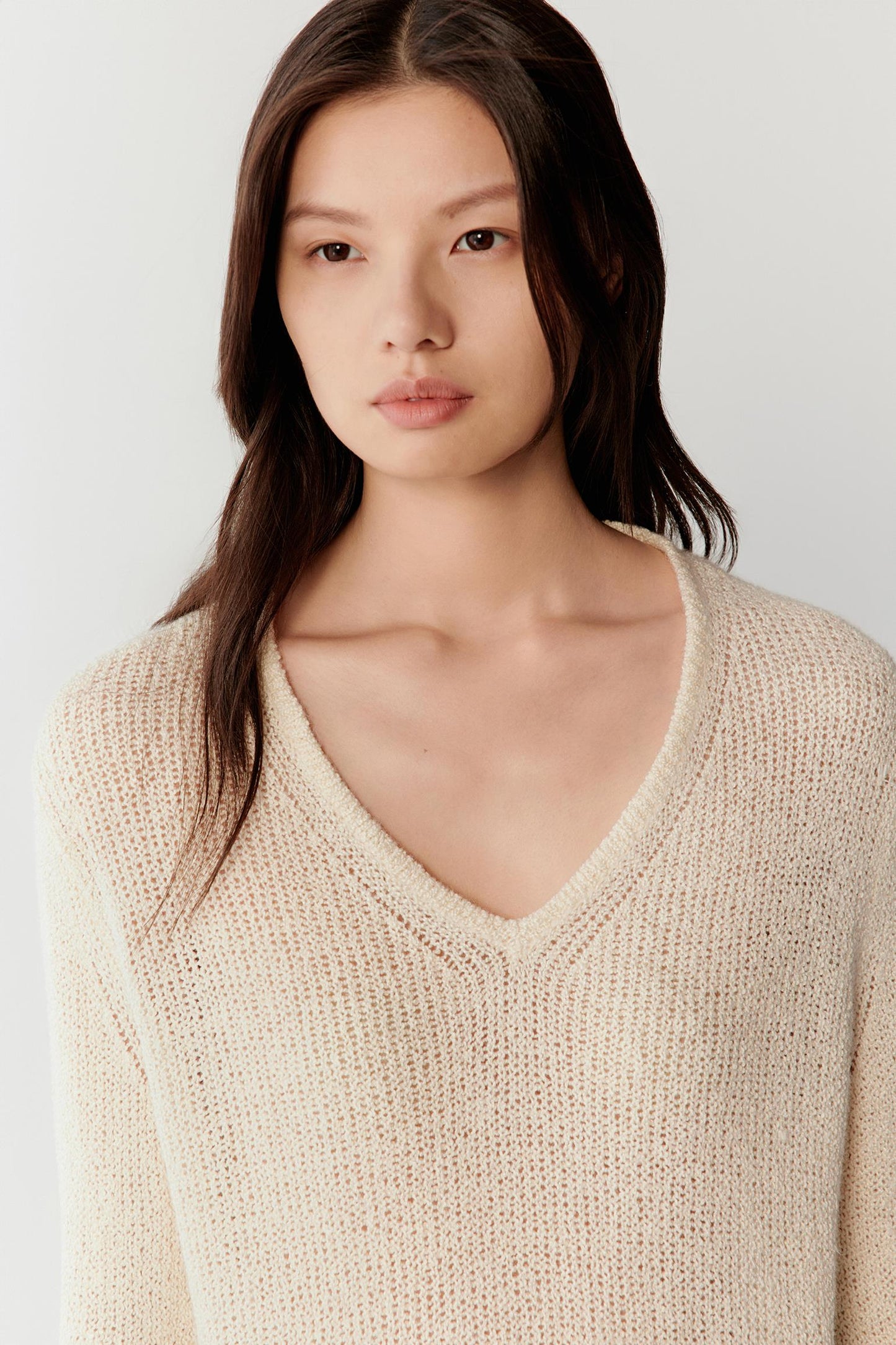 Close-up of the V-neckline and knit texture, revealing the slightly irregular surface and light, breathable construction.
