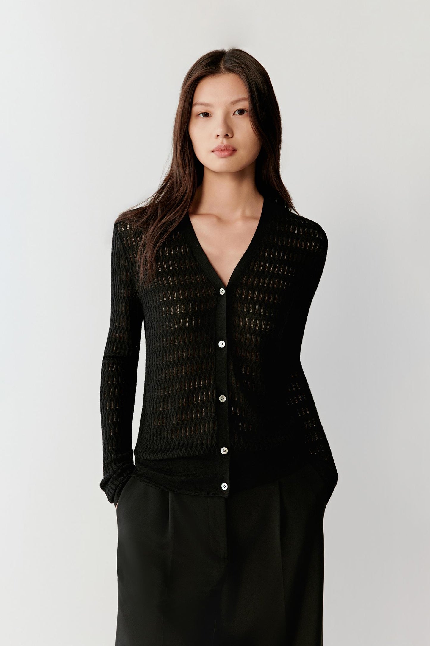 Front view highlighting the fitted silhouette, V-neck and button placket, with the lightweight openwork knit structure visible.