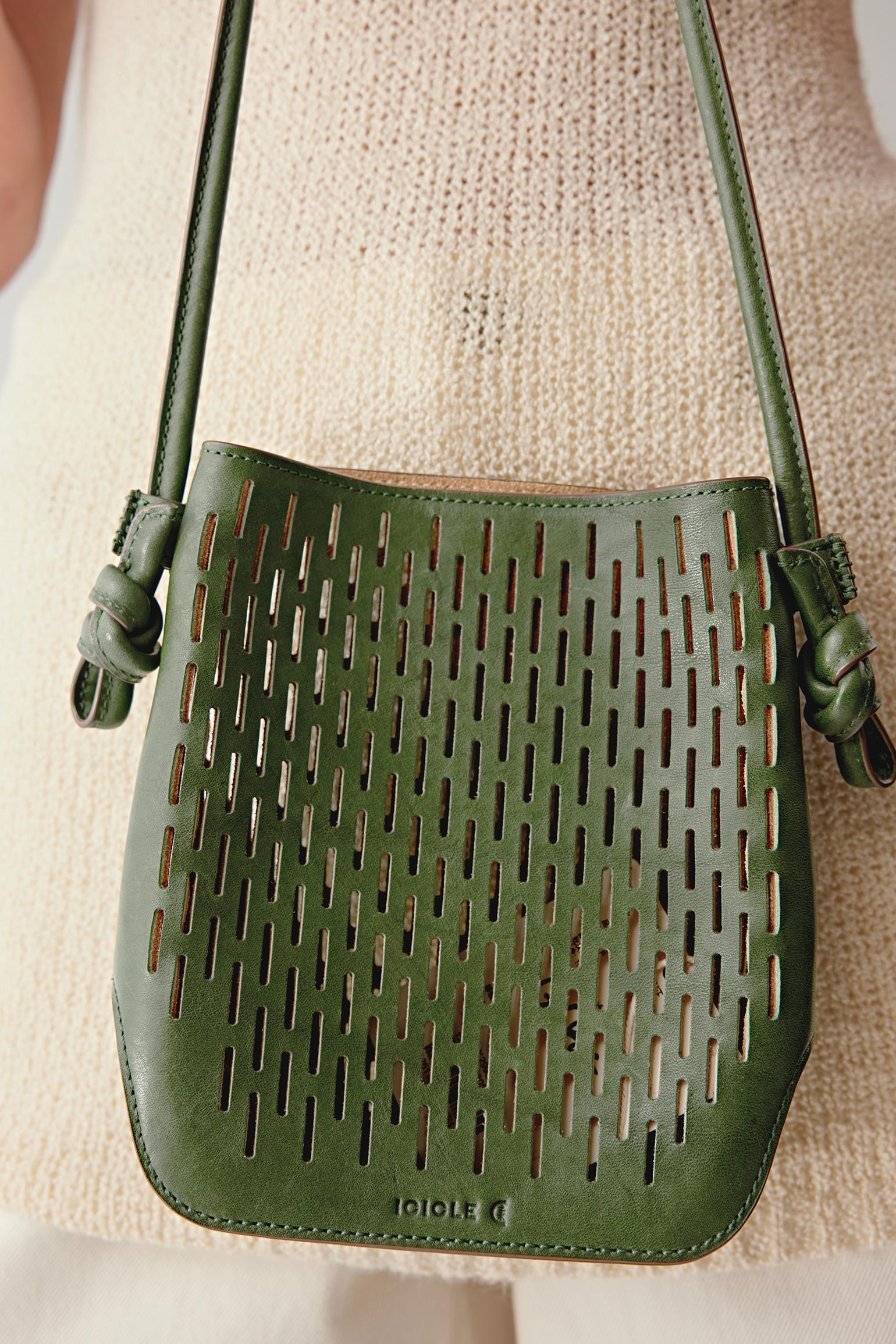 Front view of the khaki green perforated leather crossbody bag, highlighting the regular mesh pattern, flat base and structured silhouette.