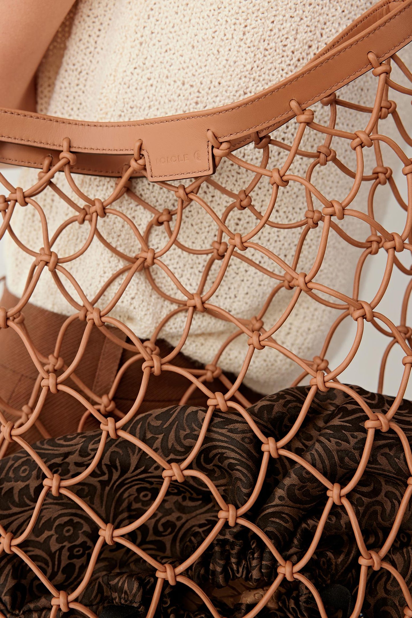 Close-up of the camel leather mesh and inner pouch, highlighting the woven structure, texture and material contrast.