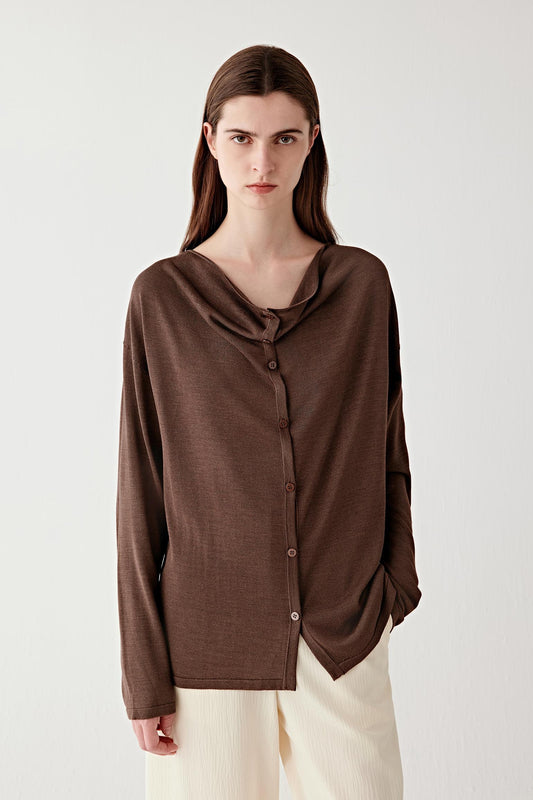 Mid-length front view focusing on the upper body, emphasizing the draped neckline, button placket and the relaxed fit through the shoulders and torso, showing how the fabric falls in soft folds across the chest