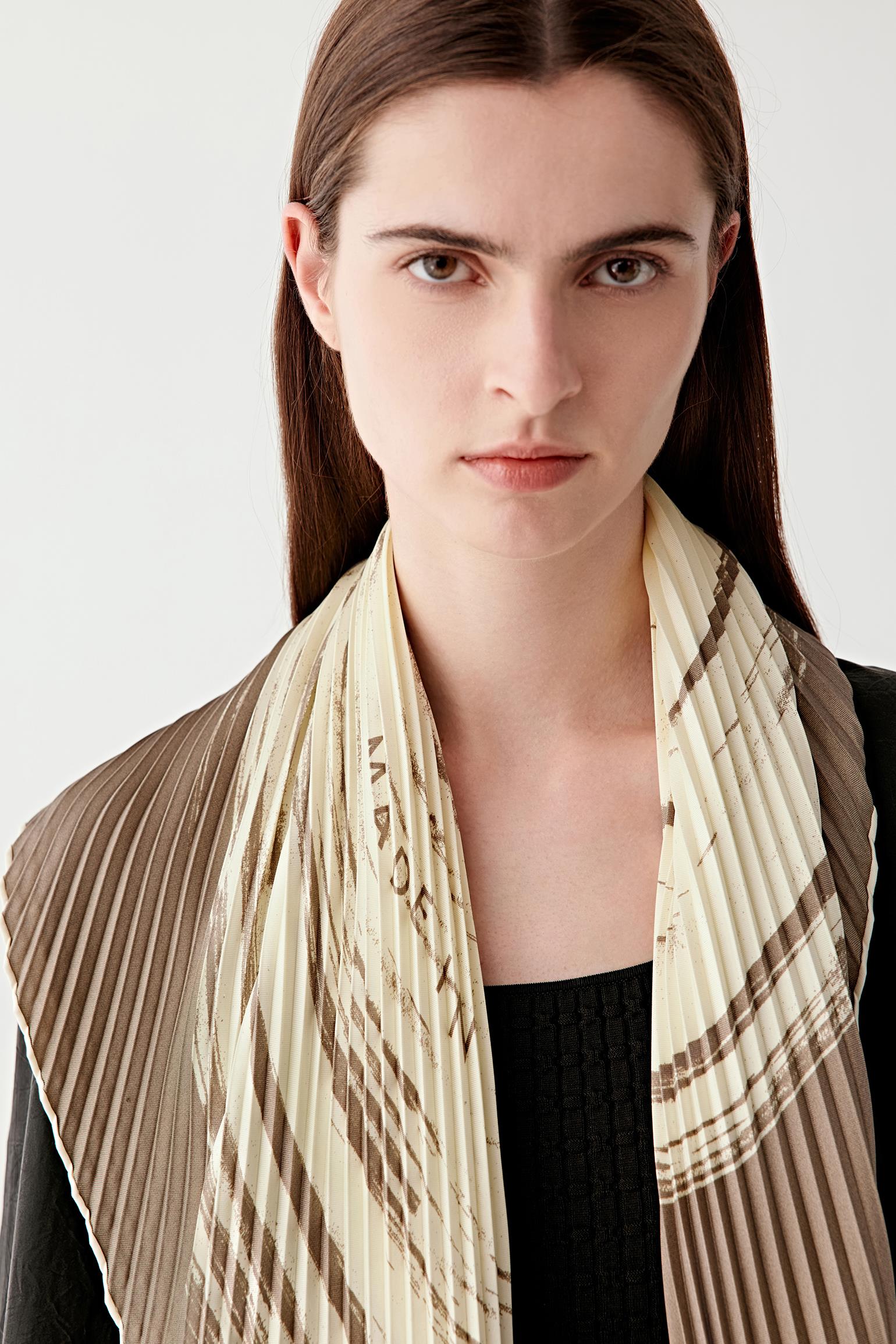 Close-up view of the scarf worn around the neck, highlighting the woven texture and natural brown tones.
