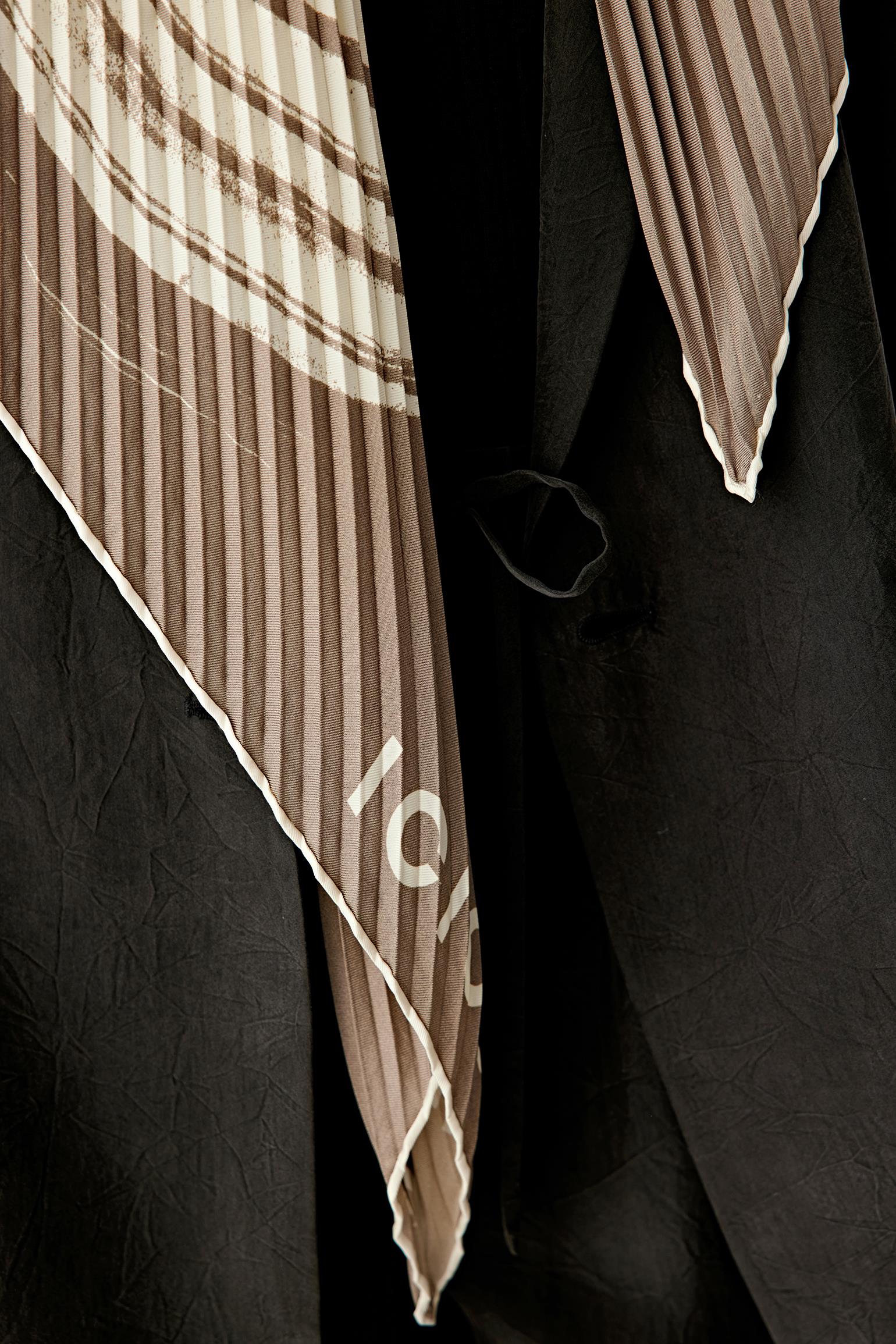 Detail view of the scarf fabric, showing subtle colour variations and the natural weave.