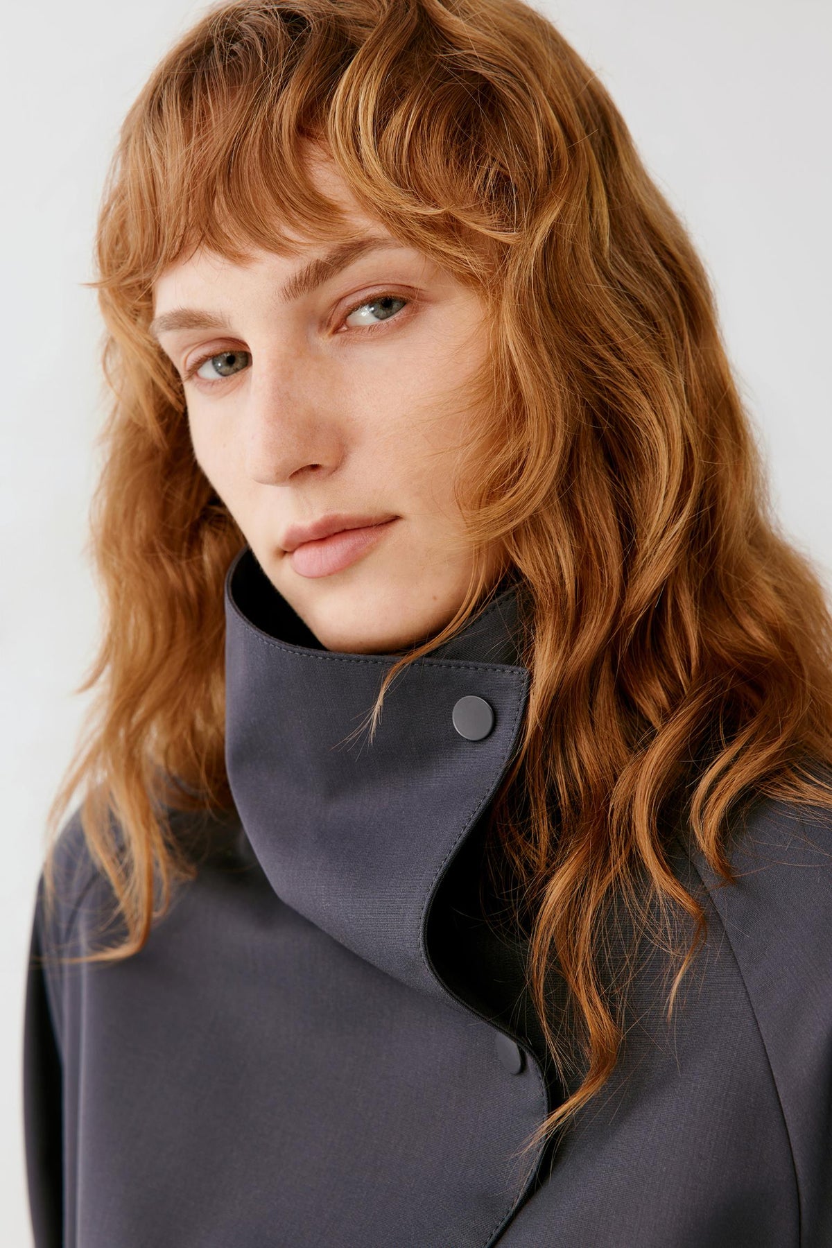 Close-up focusing on the high stand collar and upper construction, showing the smooth surface and dense plain weave of the wool.