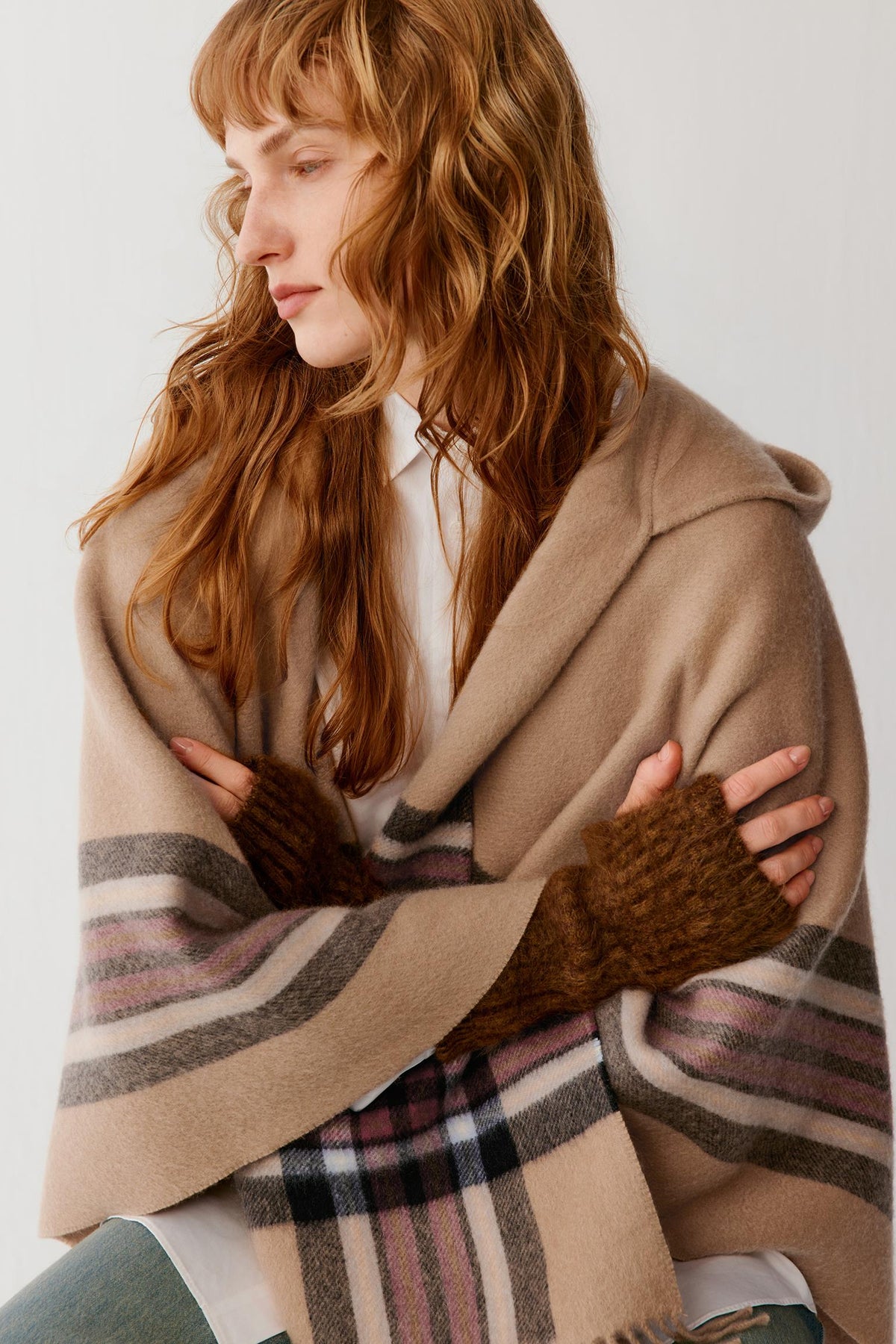 Front view of a woman wearing dark brown brushed cashmere gloves, showing the elongated shape and ribbed cuffs.
