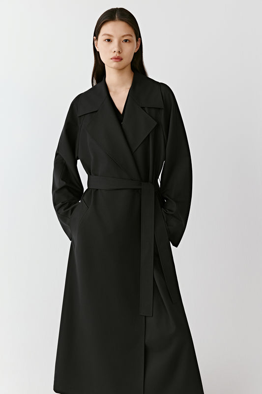 Front view showing the straight cut and minimalist design of the trench coat.