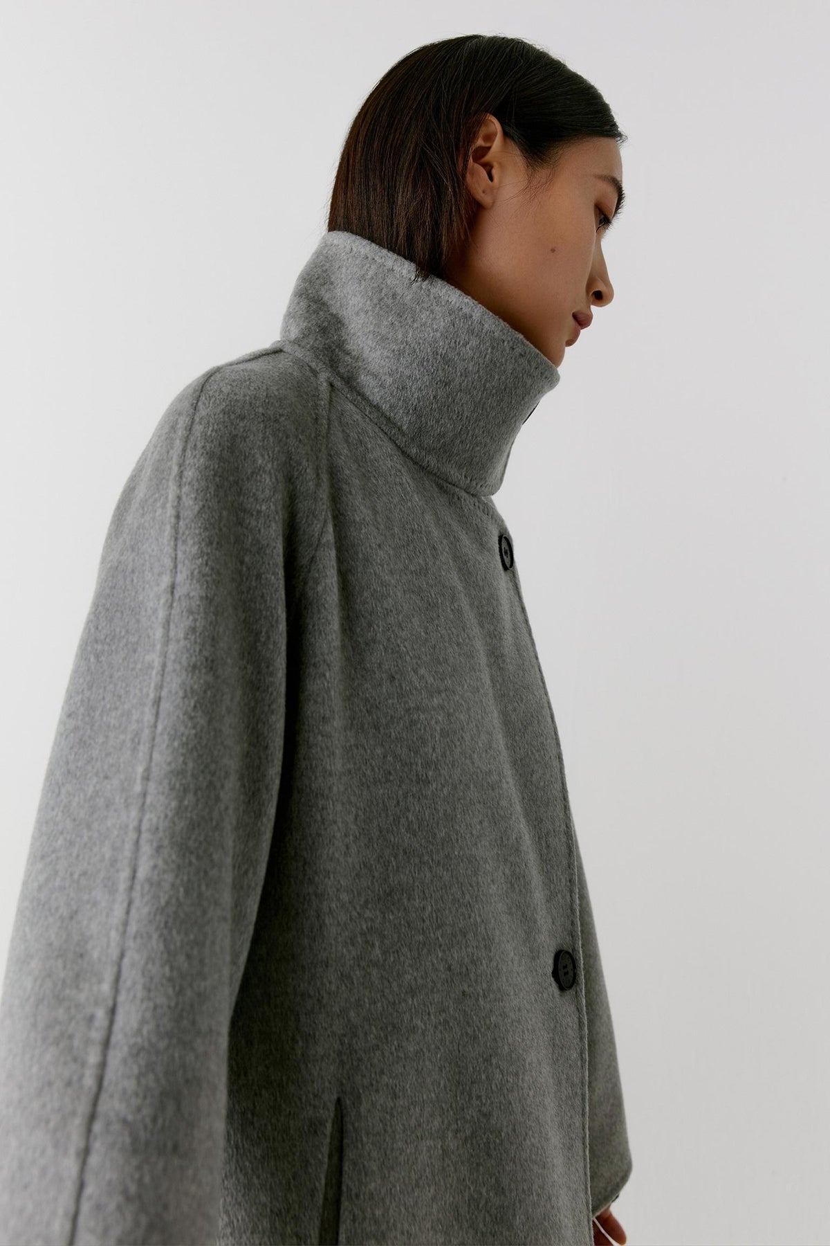 Side view highlighting the high stand collar, long silhouette and dense double-face cashmere construction.