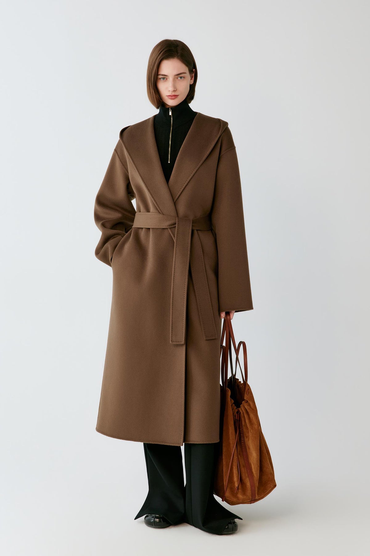 Front view of a woman wearing a rich brown double-face wool and cashmere coat, showing the hood, wrap front and long silhouette.