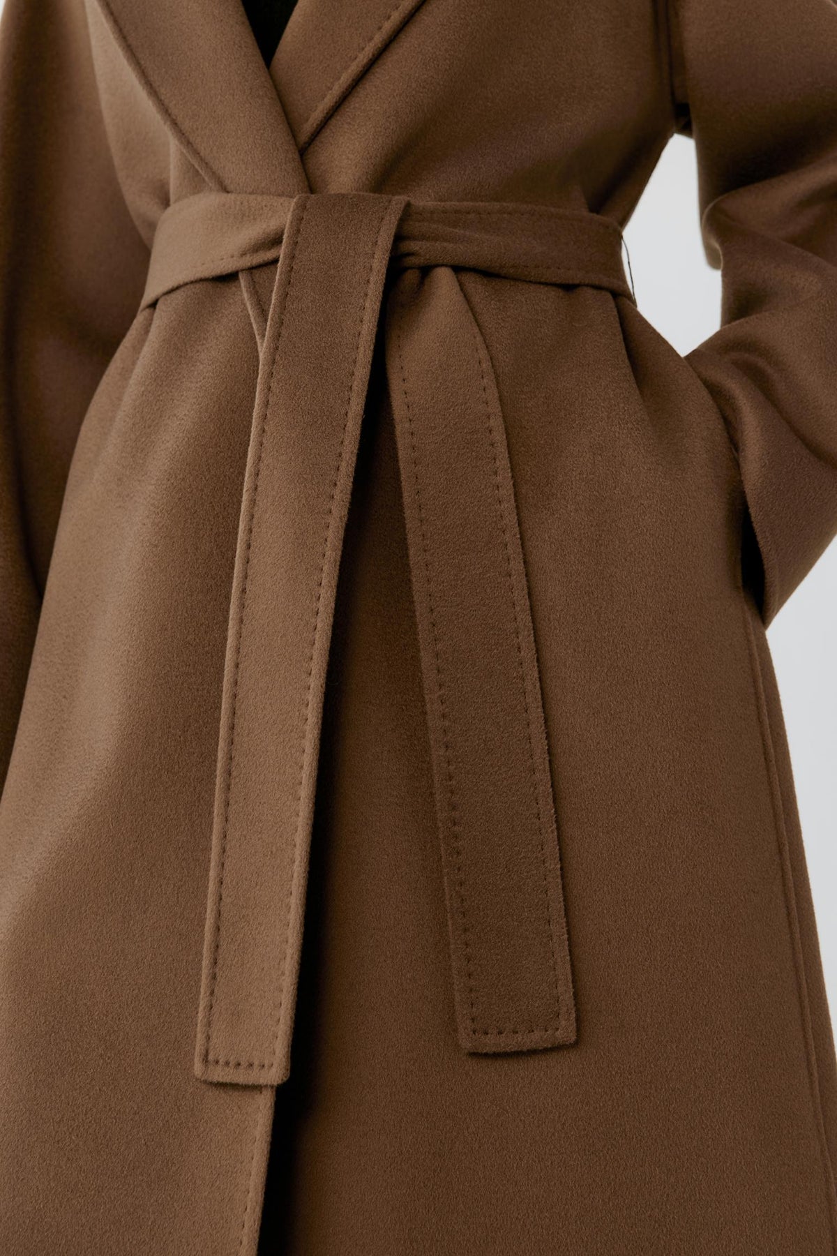 Close-up highlighting the self-tie belt, side pocket and smooth rich brown double-face surface.