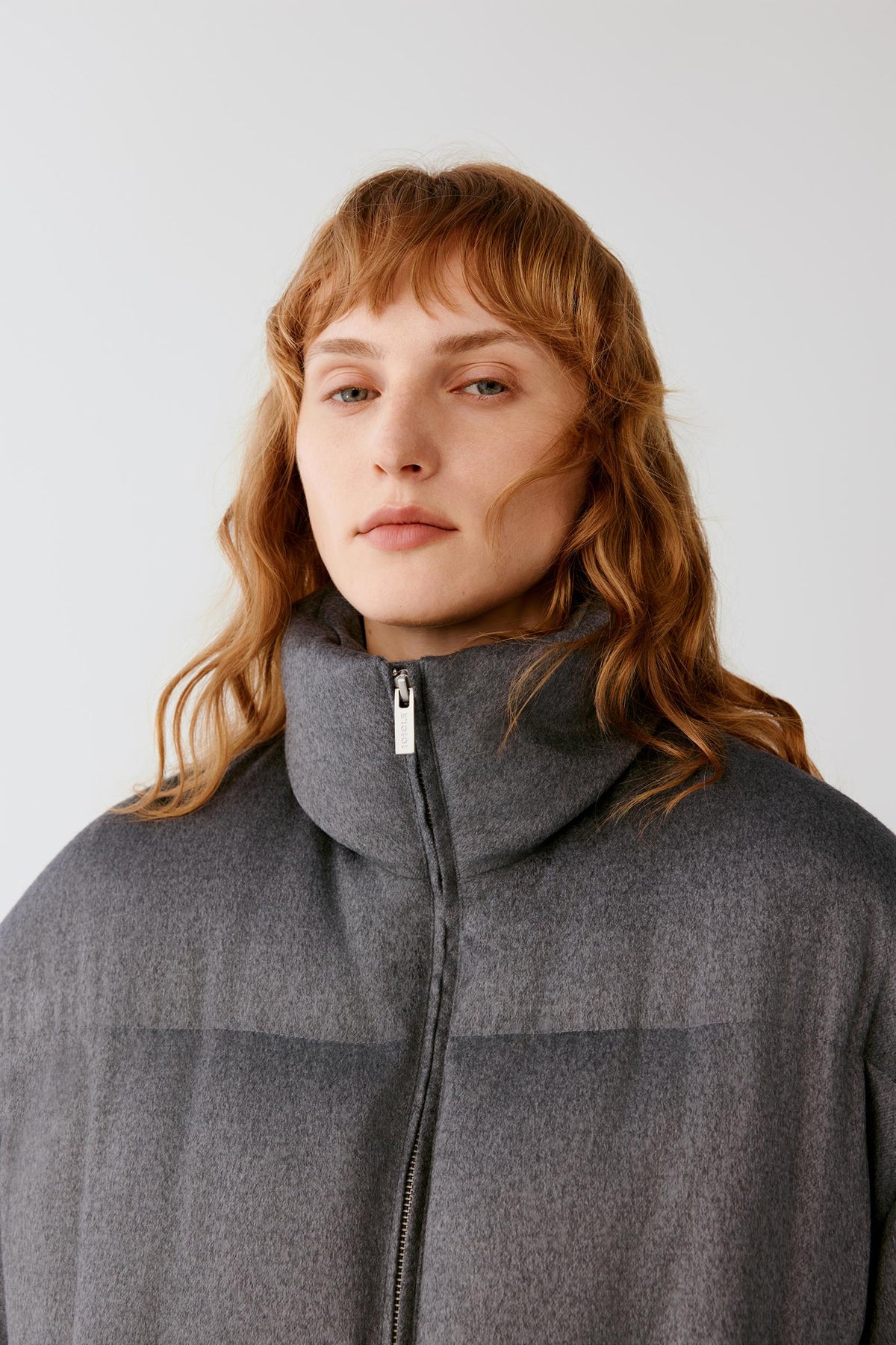 Close-up highlighting the high stand collar, front zip fastening and textured silk tweed surface.