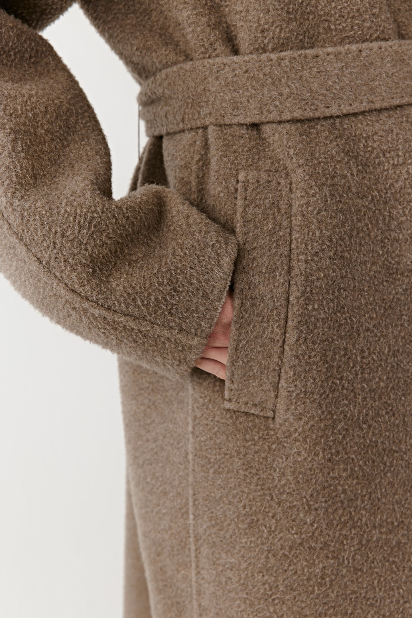 A macro view focuses on the welt pocket and fine stitching, emphasizing the craftsmanship and natural grain of the fabric.