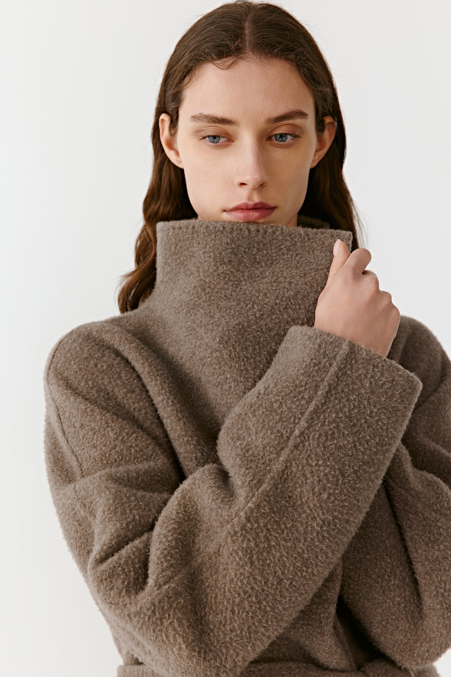 A close-up highlights the model’s upper body, showing the soft cashmere texture and elegant collar construction.
