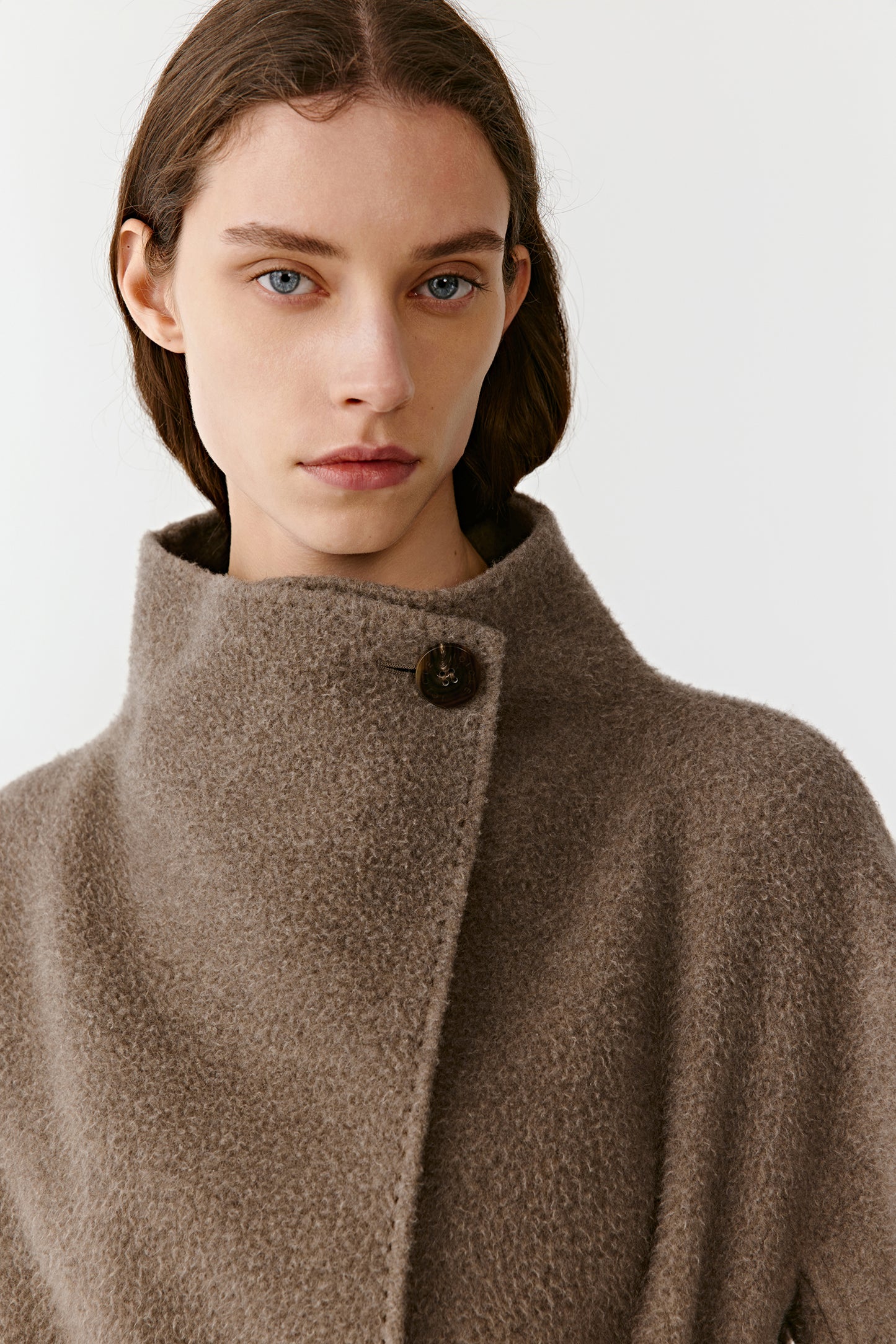 Close-up of the upper part of the brown double-faced cashmere coat, focusing on the soft shawl collar and smooth texture.
