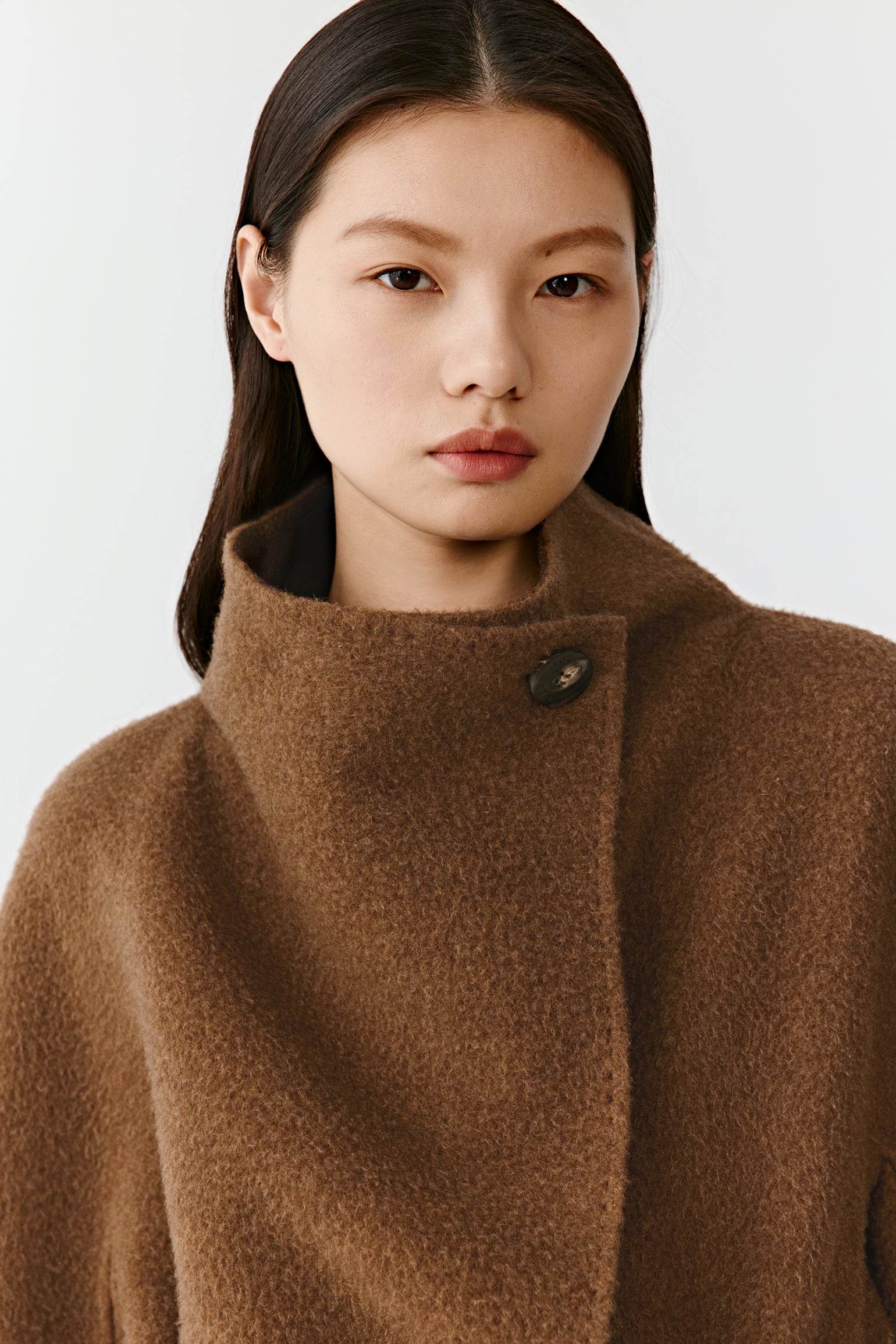 Close-up of the upper part of the double-faced cashmere short coat, focusing on the soft camel-toned shawl-style collar, smooth texture, and fine craftsmanship.