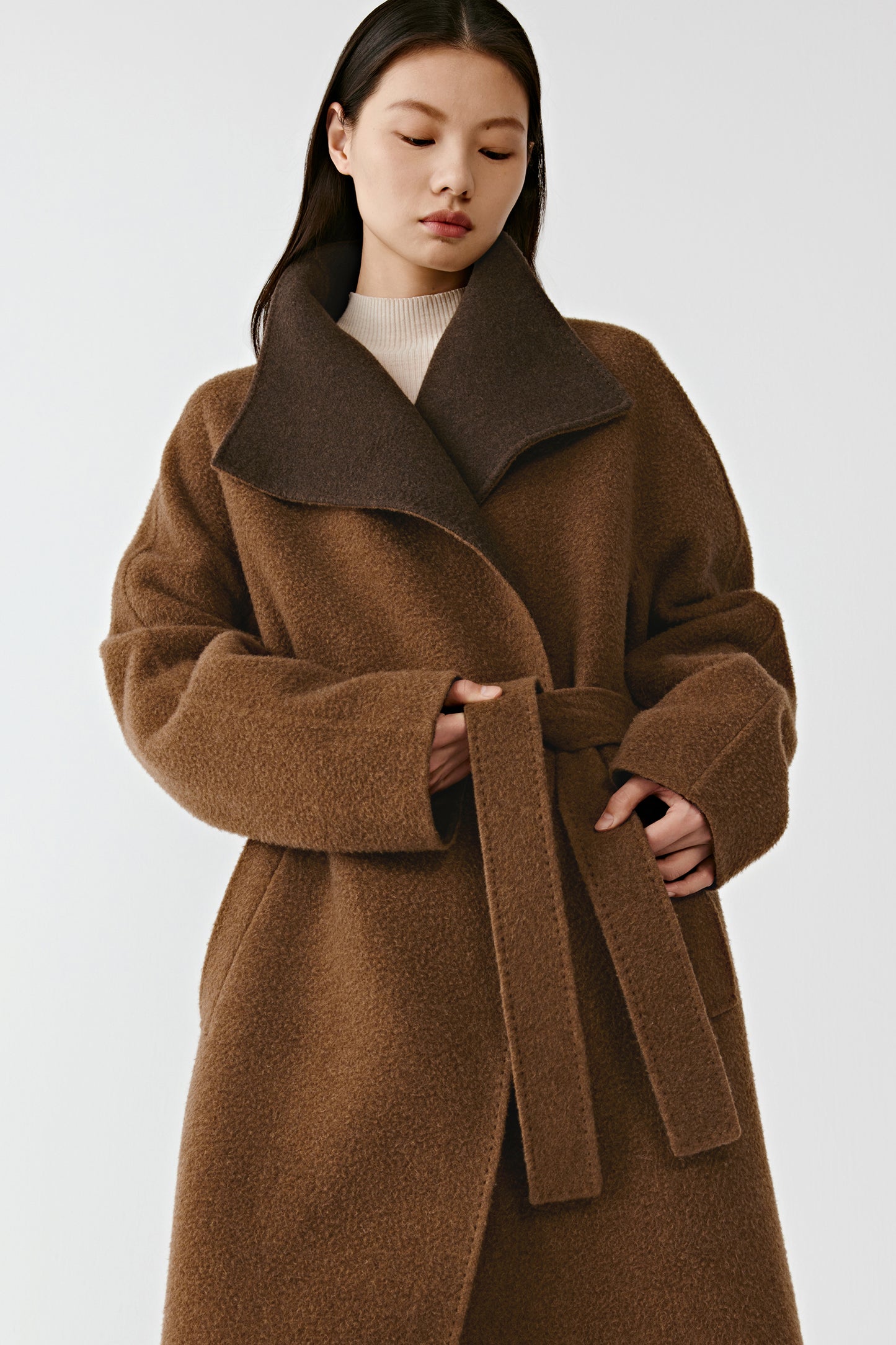 A closer shot captures the upper body, highlighting the shawl collar’s sculpted shape and the soft texture of the cashmere.