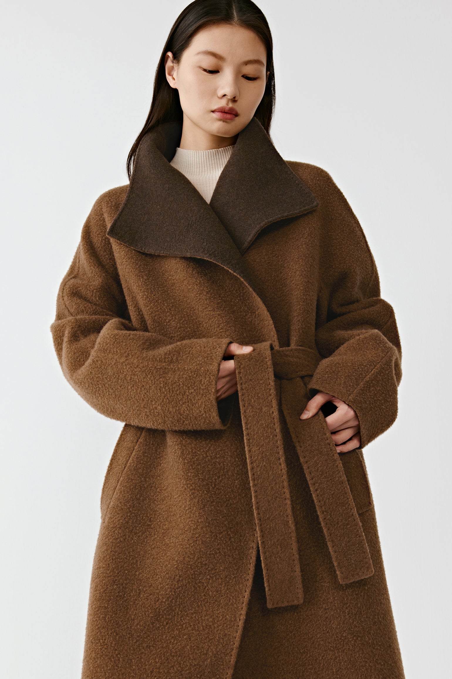 A closer shot captures the upper body, highlighting the shawl collar’s sculpted shape and the soft texture of the cashmere.