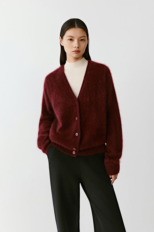 Three-quarter front view of a person wearing a deep red cashmere cardigan, showing the soft brushed texture and relaxed fit.