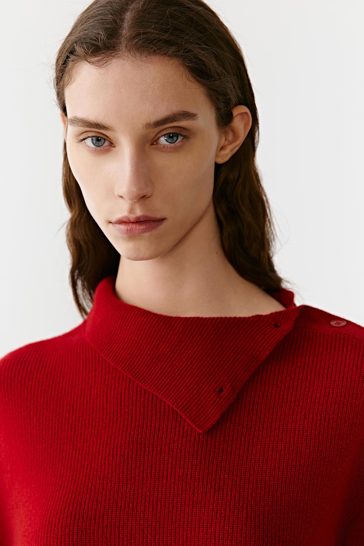 Close-up of the high neck of the red cashmere pullover, showing a dense, refined knit.
