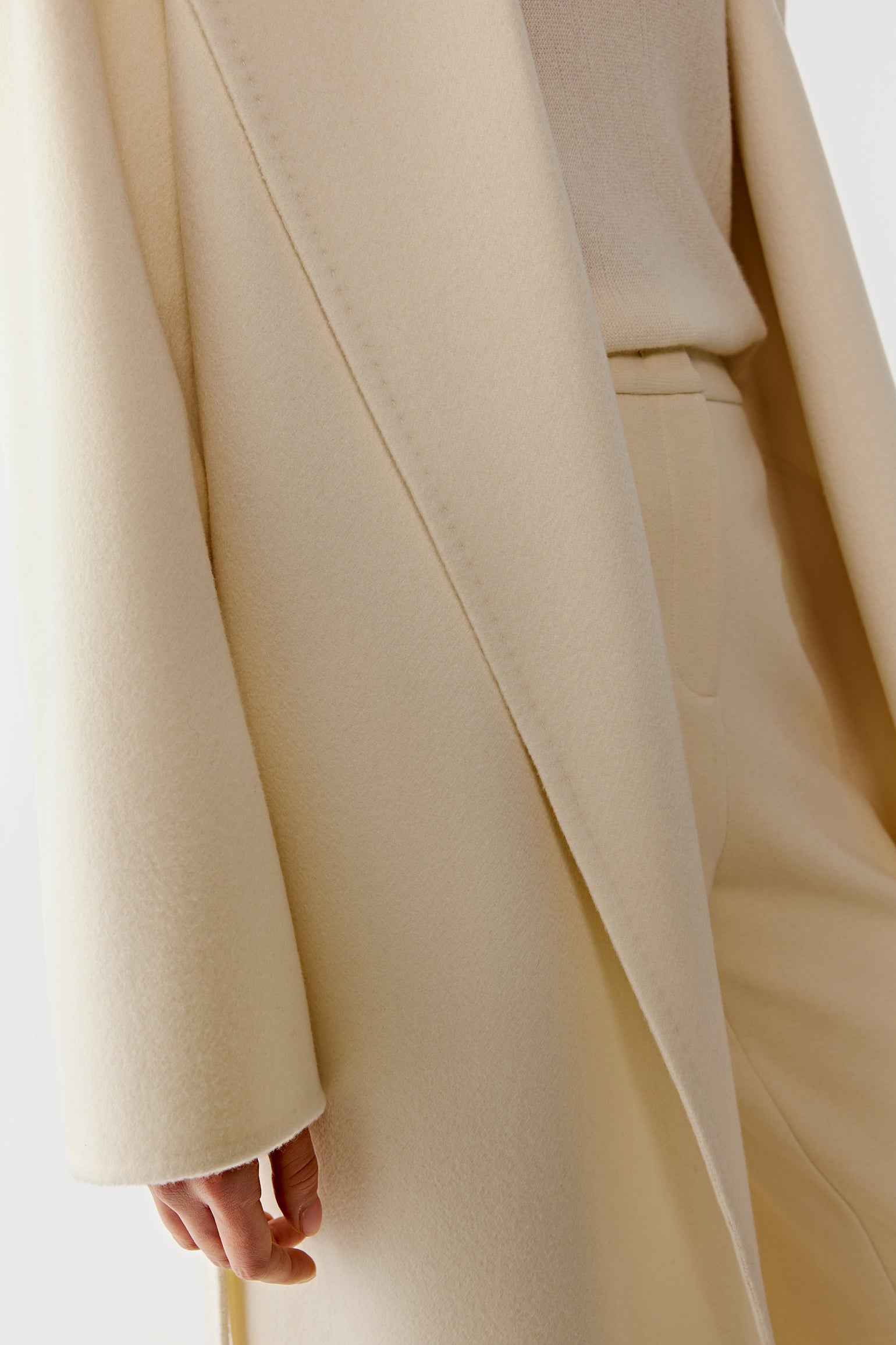 Detail close-up of the sleeve and fabric texture of the double-faced cashmere coat.