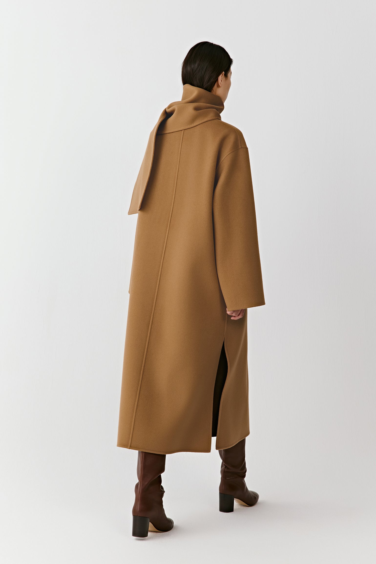 Back view of the straight camel coat, showing its long silhouette and smooth double-faced fabric.
