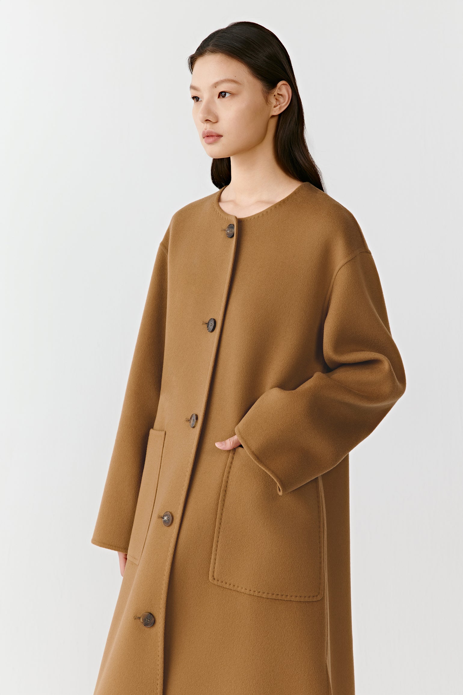 Side view of the double-faced wool and cashmere coat, showing the fluid drape and practical patch pockets.