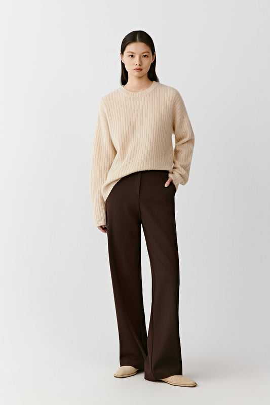 Full-length front view of straight-leg trousers in deep brown stretch worsted wool, styled with a light knit top.