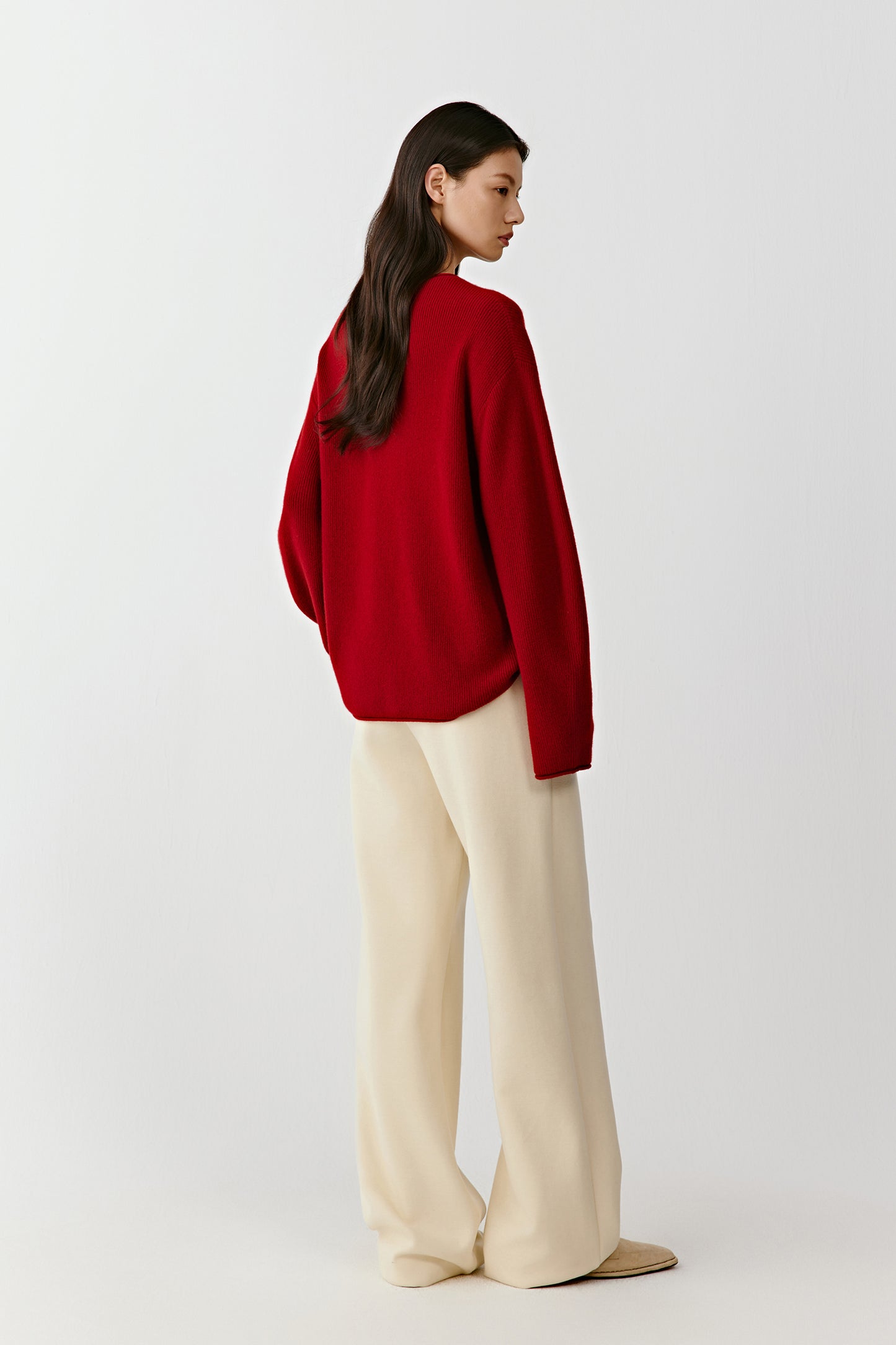 Full-length back view of the red cashmere V-neck pullover, showing a clean straight cut and smooth knit texture across the back.