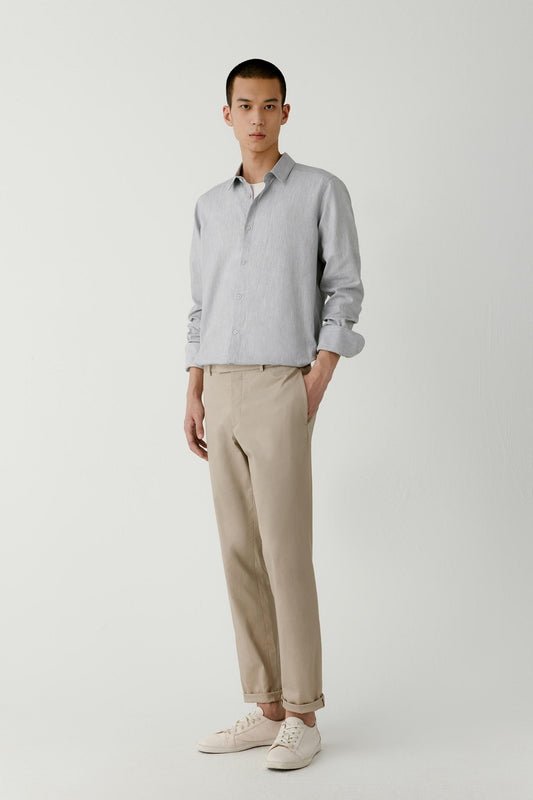 Man wearing a light grey melange cotton straight-fit shirt, styled with beige trousers, full-length front view.